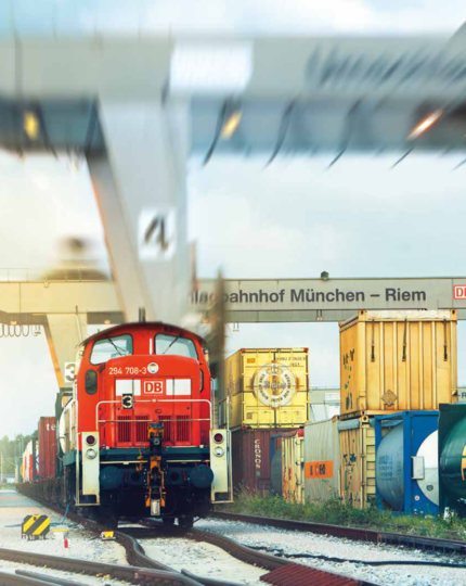 Kombiverkehr freight train in motion at Munich-Riem transfer station.