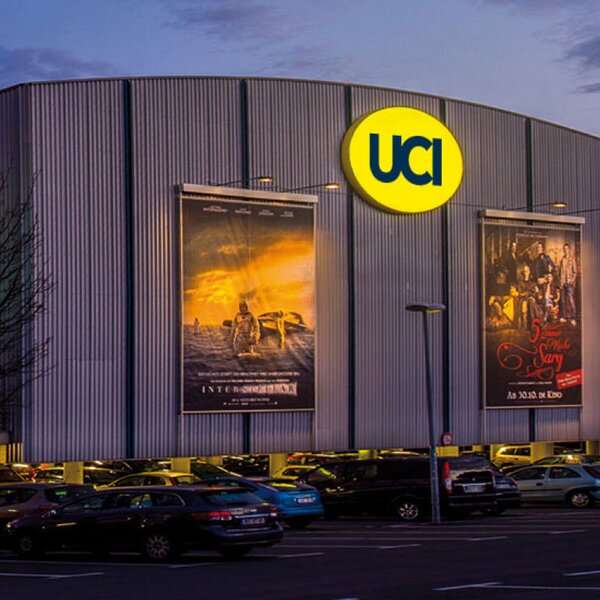 Exterior view of UCI Kinowelt in Bochum with colorful illuminated facade at twilight. | © UCI Kinowelt