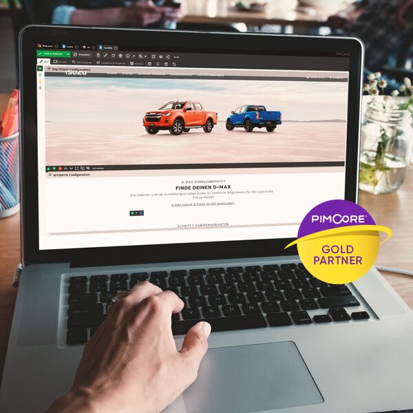 Person betrachtet die Modellauswahl des ISUZU D-MAX auf einem Laptopbildschirm mit sichtbarer offizieller Webseite und einem Pimcore Gold Partner Logo