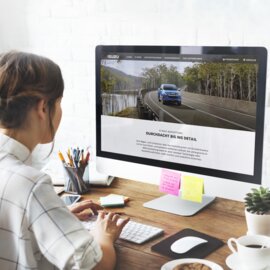 Person, die sich die ISUZU D-MAX-Website auf einem Monitor in einer Büroumgebung ansieht. | © Freepik Premium licence