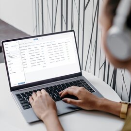 Person working on a laptop with data spreadsheet.