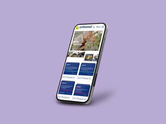A smartphone on which an Orthomol customer reference from the Krankikom GmbH portfolio is presented.