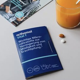 Orthomol Vital F product sample Orthomol Vital F sample packaging with tablets and orange juice.